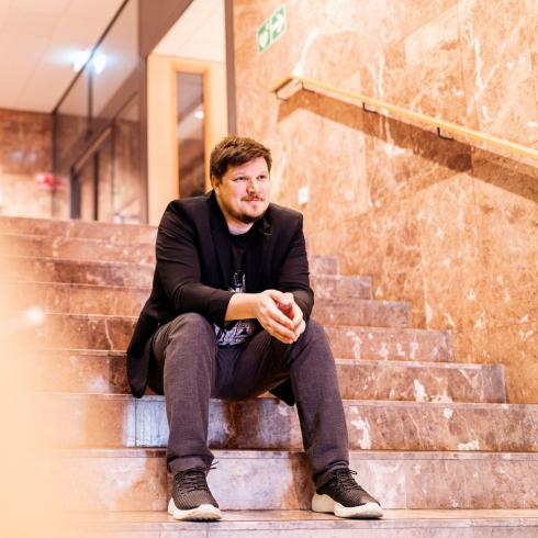 Tietoturva-asiantuntija Benjamin Särkkä istuu portailla.